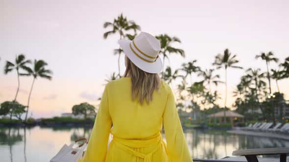 Scenic Zoom Dolly Shot Girl Looking at Green Palms in Sunset Sky Traveler Hat alt