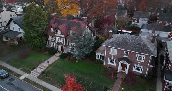 Aerial establishing shot of upscale expensive mansions in American suburb. Slow motion of car drivin alt