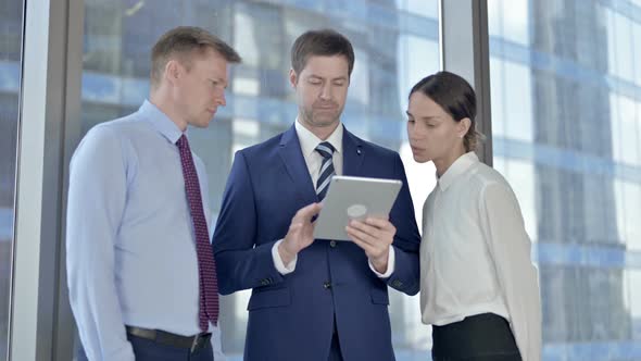 Middle Aged Business People Using Tablet and Get Shocked in Office alt