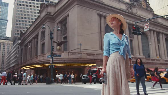 Attractive girl with a retro camera at the Grand Central Terminal alt