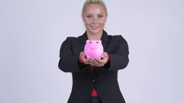 Young Happy Blonde Businesswoman Giving Piggy Bank alt