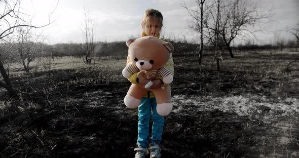 Orphan Child in the Colors of the Ukrainian Flag with a Toy Bear in Ukraine War alt