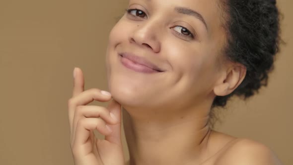 Beauty Portrait of Young African American Woman Coquettishly Looking at Camera and Blowing Kiss alt