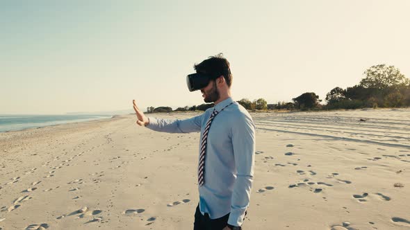 Business Boy with Virtual Reality Headset Walks at the Beach Near the Sea alt