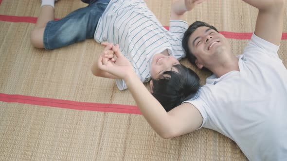 Father and son play together by lie on mat in home garden and they look happy
