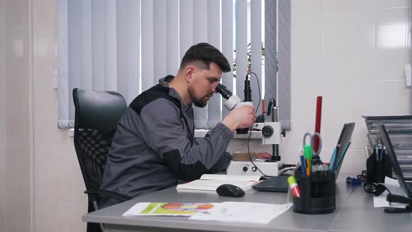 Man Working with a Microscope in a Laboratory