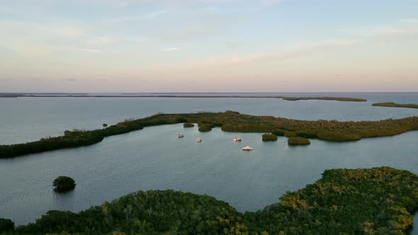Pleasure Boats Floating In The Calm Waters Of Florida Keys At Sunset. - aerial pullback alt