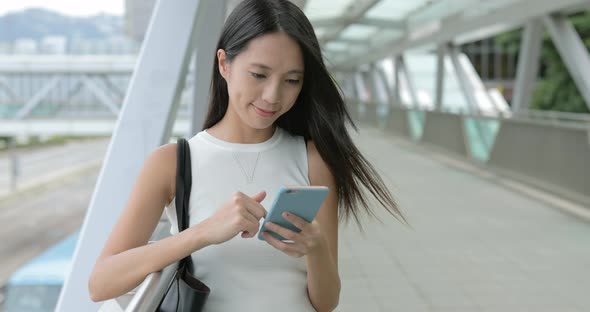 Woman using cellphone in the city  alt