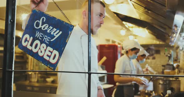 Street Food Cafe is Opening Waiter Turns Plate From Closed to Open