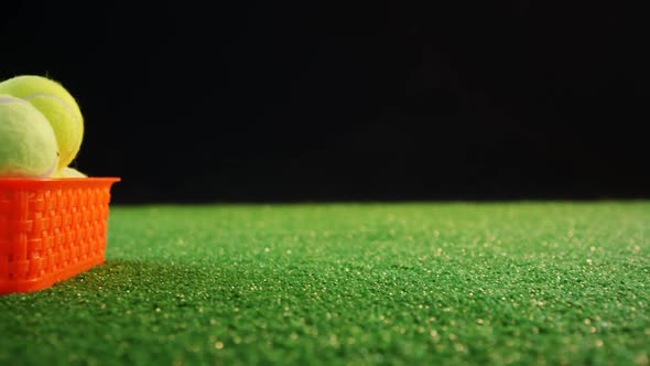 Tennis balls in red basket at studio 4k alt