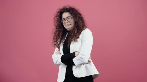 The Young Woman with Curly Hair Feels Disturbed By the Noise Putting Her Fingers in Her Ears alt