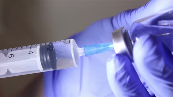 Doctor's Hands Fill the Syringe with Vaccine, Preparing for the Injection of the Injection To the