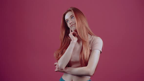 Intelligent 20Yearold Redhead in Pink Casual Tshirt Isolated on Pink Background alt