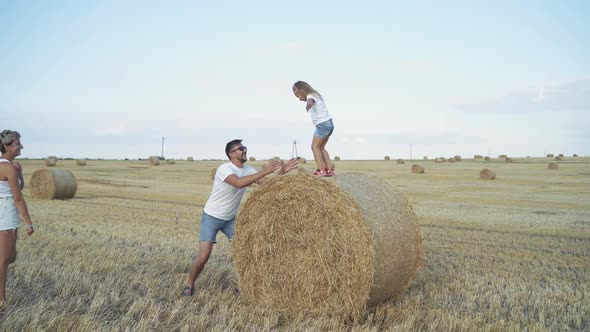 Little Girl Jumps Into Father's Hands and Mother Comes and Embraces alt