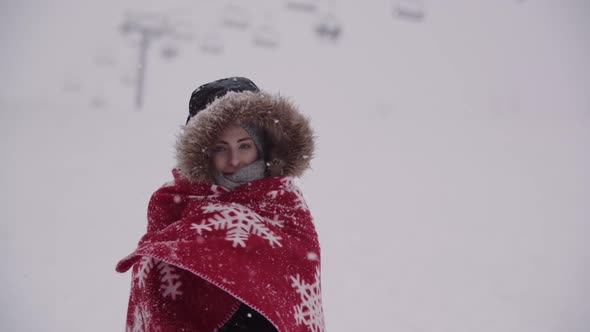 Close Up of Frozen Woman Wrapped in a Blanket at Snowstorm alt