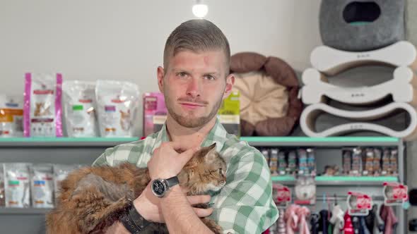 Handsome Young Man Smiling To the Camera, Holding Cute Cat in His Arms alt