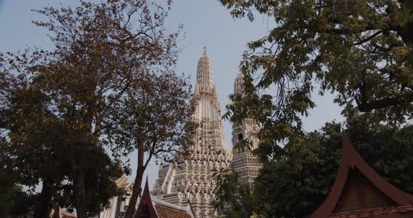 Tilted Upward Shot of Wat Arun Temple in Thailand Against Blue Skies alt