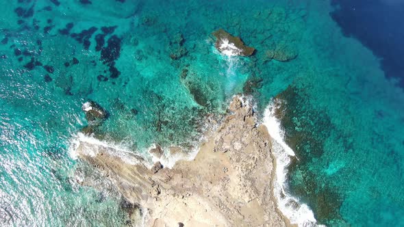 Top View of Crystal Clear Water Rolling on Deserted Rocky Coast. Aerial View of Transparent Waves of alt