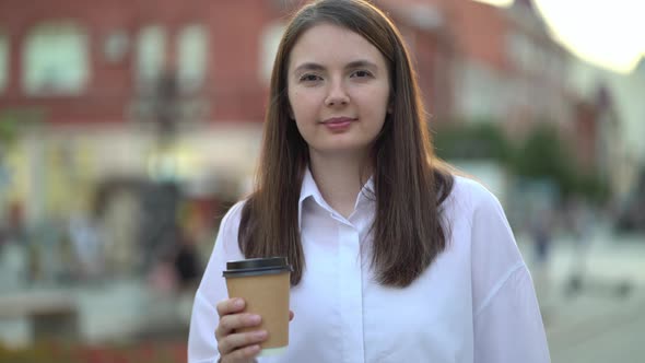 Portrait of a Businesswoman Holding Hot Coffee in Her Hands and Looking at the Camera