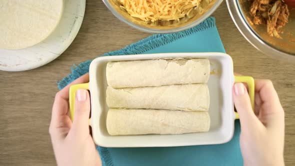 Chicken enchiladas with cheddar cheese and sauce. alt