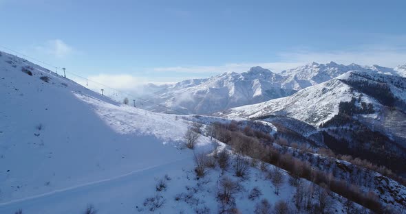 Side Aerial on White Snow Mountain Peak in Winter Revealing Skier Ski Chair Lift