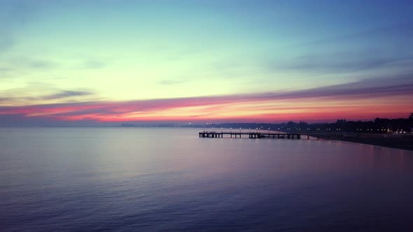 Early morning on the beach just before the sunrise. Drone footage. Orange and purple sky. Relaxing s alt
