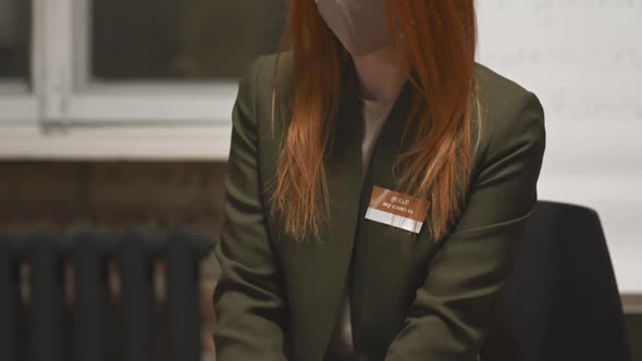 Red Haired Woman in Face Mask at Group Therapy Session alt