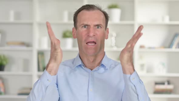 Portrait of Upset Middle Aged Businessman Reacting to Failure alt