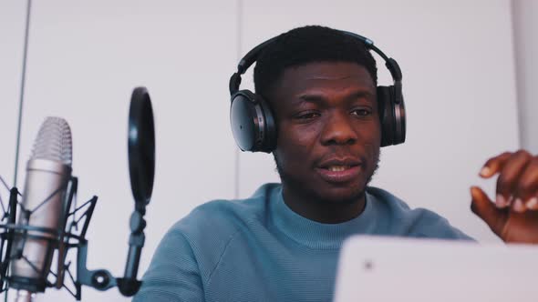 Man Wearing Headphones Taking an Online Class Using a Laptop and Microphone alt