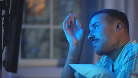 Handsome Young Man Watching Melodrama Hugging Pillow and Crying alt