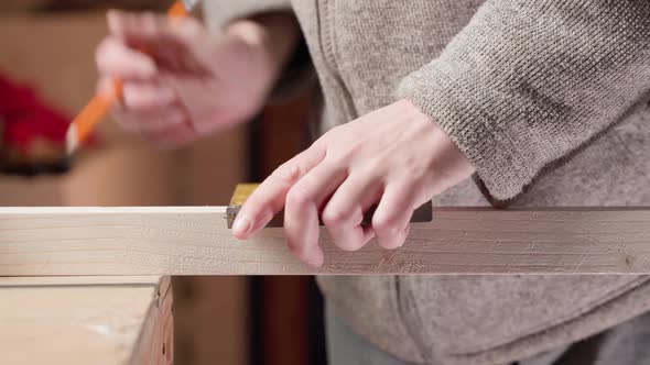 The Guy Notices the Length of the Wooden Square and Draws a Straight Line with a Square alt
