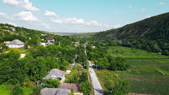 Aerial drone view of nature, valley with village, hills, greenery, Moldova alt