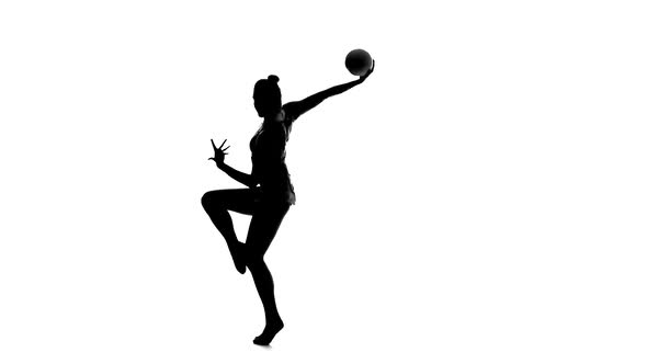 Gymnast To Be Turned with the Ball in His Hands. White Background. Silhouette. Slow Motion alt