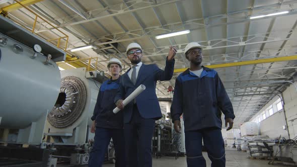  Manufacturing Engineer and Workers Walking in Factory alt