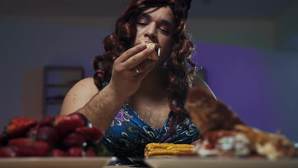 Man Dressed in Woman's Dress and Makeup on Face Eats a Huge Sandwich
