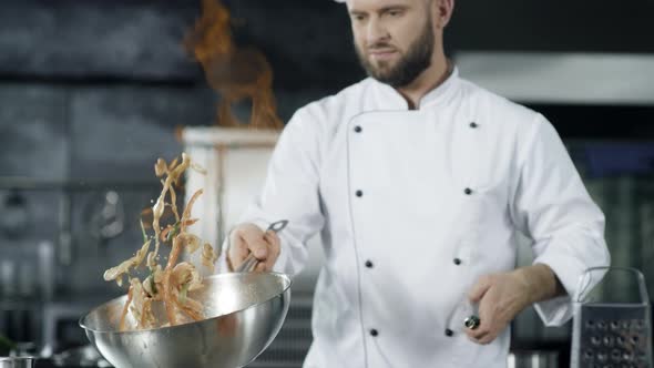 Chef Cooking Food with Burning Fire in Slow Motion. Focused Chef Throwing Food alt