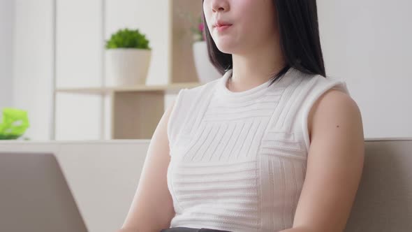 Asian businesswoman serious focus typing on laptop keyboard for work from home alt