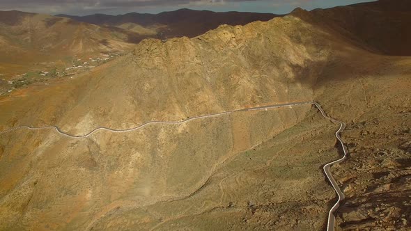 Aerial view of the winding mountain road between two villages of Fuerteventura. alt