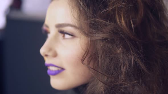 Makeup Artist Uses Brush to Apply Lipstick to Model's Lips alt