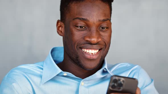 Smiling young student sending a message using a smartphone alt