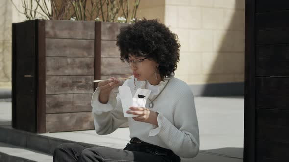 African american girl eating lunch on the street alt