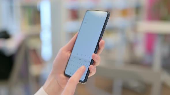 Rear View of Female Hands Typing on Smartphone alt