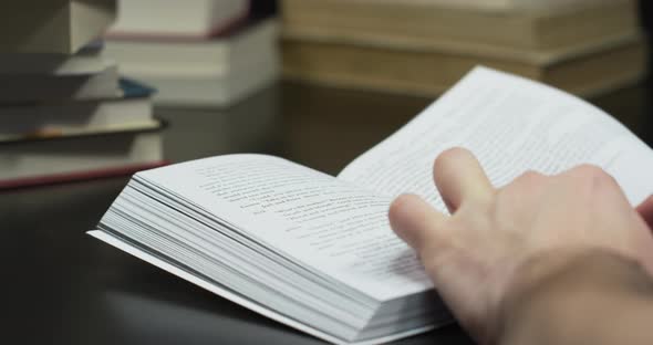 Person reading and turning pages of a book alt