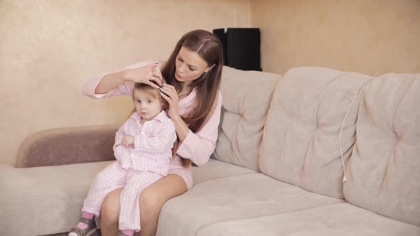 Young Beautiful Woman Holding Little Child on Her Knees