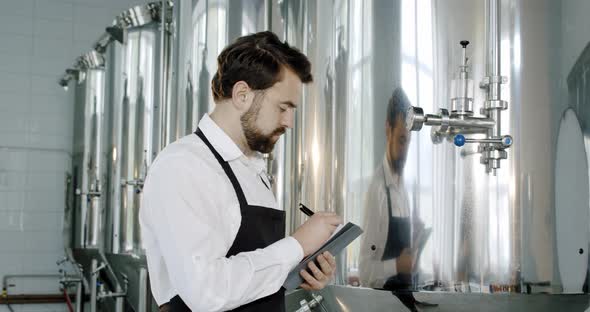 Brewery Worker Checking Beverage Equipment at Brewery or Beer Plant. Beer Production. alt