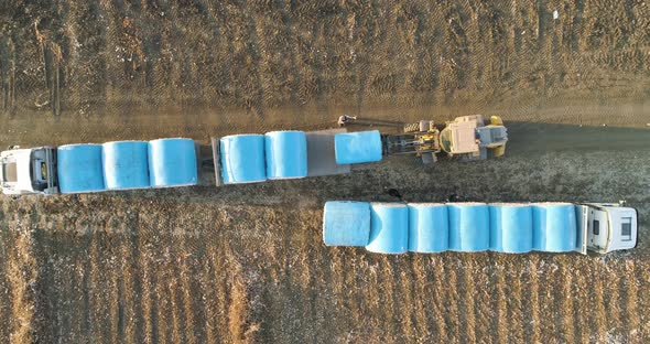 Aerial view of a tractor loading cotton bales on truck, Israel. alt