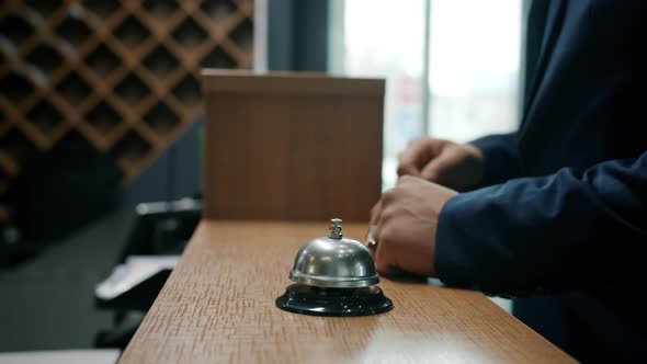 Closeup of Male Hands Ringing Call Bell in Hotel Taking Key Card From Receptionist alt