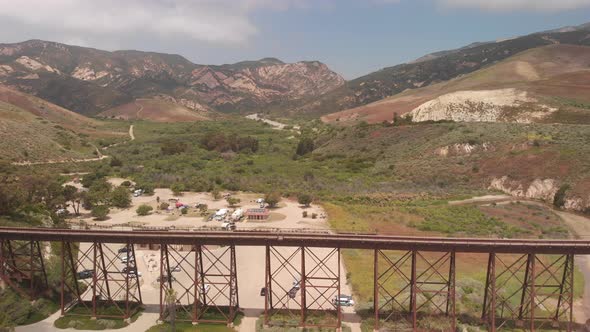 Drone flies over train track and ocean pier in Santa Barbara