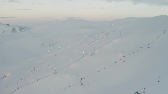 Ski Resort Chairlifts in Blafjoll, Iceland - Aerial Flyover Above Snowy Slopes alt
