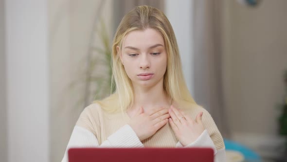 Portrait of Concentrated Young Woman Learning Sign Language Online Gesturing and Looking at Laptop alt
